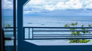 A view from a window with a railing, overlooking a body of water and a cloudy sky. - Ndau Lodge (Nkhata Bay)