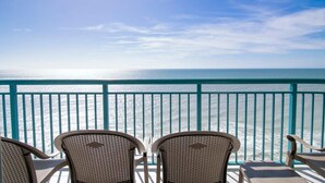 A balcony with four wicker chairs facing a turquoise railing overlooking the ocean. - Oceanfront 3 BR Condo 19th floor (Myrtle Beach)
