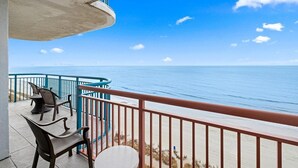 A balcony with a view of the ocean, a table, and two chairs. - Four Bedroom Oceanfront Condo 19th Floor! (Myrtle Beach)