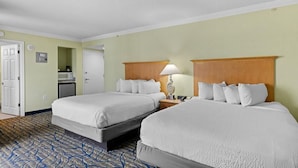 A hotel room with two beds, a desk with a lamp, a microwave, and a door. - Four Bedroom Oceanfront Condo 20th Floor! (Myrtle Beach)