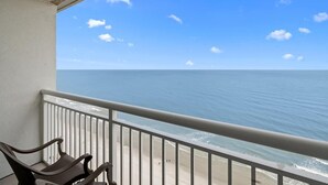A balcony with a view of the ocean and beach.