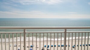 Un balcon avec vue sur la plage et l’océan.