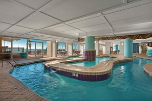 Piscina interna com vista clara para o oceano, área de estar com cadeiras e um grande pilar.