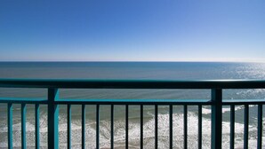 A view from a balcony with a railing, overlooking a calm sea and a clear sky. - Amazing Views from 20th Floor! Sleeps 8 (Myrtle Beach)