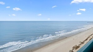 A beach with a clear sky and calm sea.