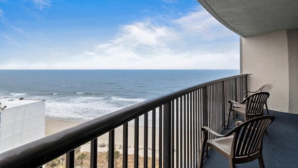 A balcony with a view of the ocean, featuring a railing and two chairs. - Newly Renovated Ocean View 2 Bdrm Condo 12th Flr (Myrtle Beach)