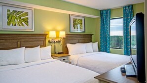 A hotel room with two beds, a TV, and a window with curtains. - Coastal Serenity: Ocean View 2 Bdrm Condo 15th Flr (Myrtle Beach)