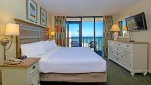 A hotel room with a bed, a dresser, a television, and a balcony with a view. - Coastal Serenity: Ocean View 2 Bdrm Condo 15th Flr (Myrtle Beach)