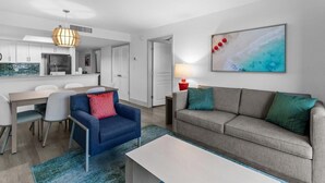 Een moderne woonkamer met een bank, een salontafel en een eethoek met stoelen en een tafel.