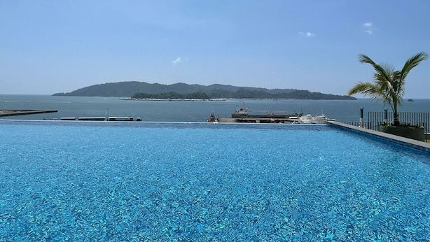 A clear blue pool with a view of the sea and a distant island. - Jesselton Quay 23A Sunset Seaview  (Kota Kinabalu)