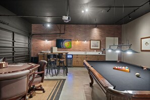 A billiards room with a pool table, bar stools, and a television. - Pickleball | Putting Green | 5 BR | 3 mi to Disney (Anaheim)