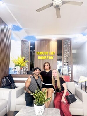 A modern interior with a ceiling fan, a sofa, a coffee table with a plant, and decorative panels. - Tam Coc LiLy Homestay (Nam Hoa Lu)