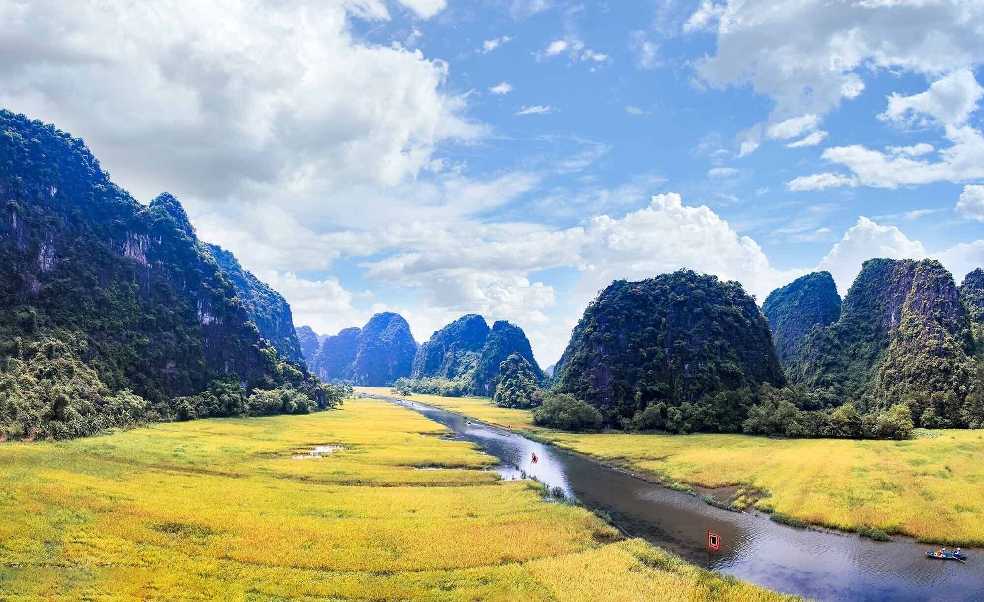 A river running through a lush valley with dense forests on either side.