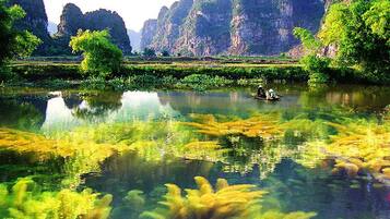 A calm river with a boat and lush greenery.