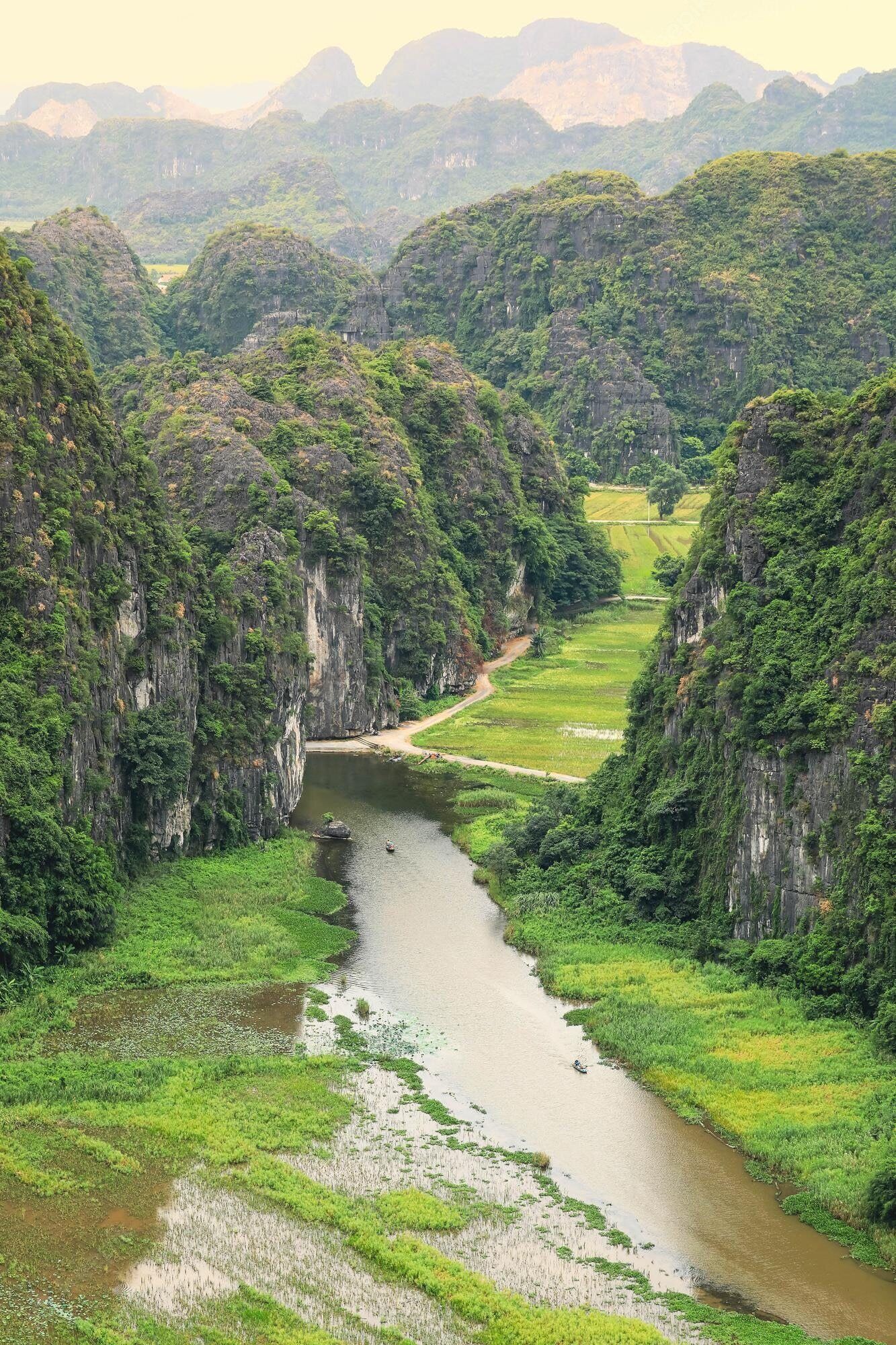 A river winding through a lush valley with steep cliffs on either side.