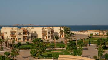 A resort with a central amphitheater, multiple-story buildings, and a view of the sea.