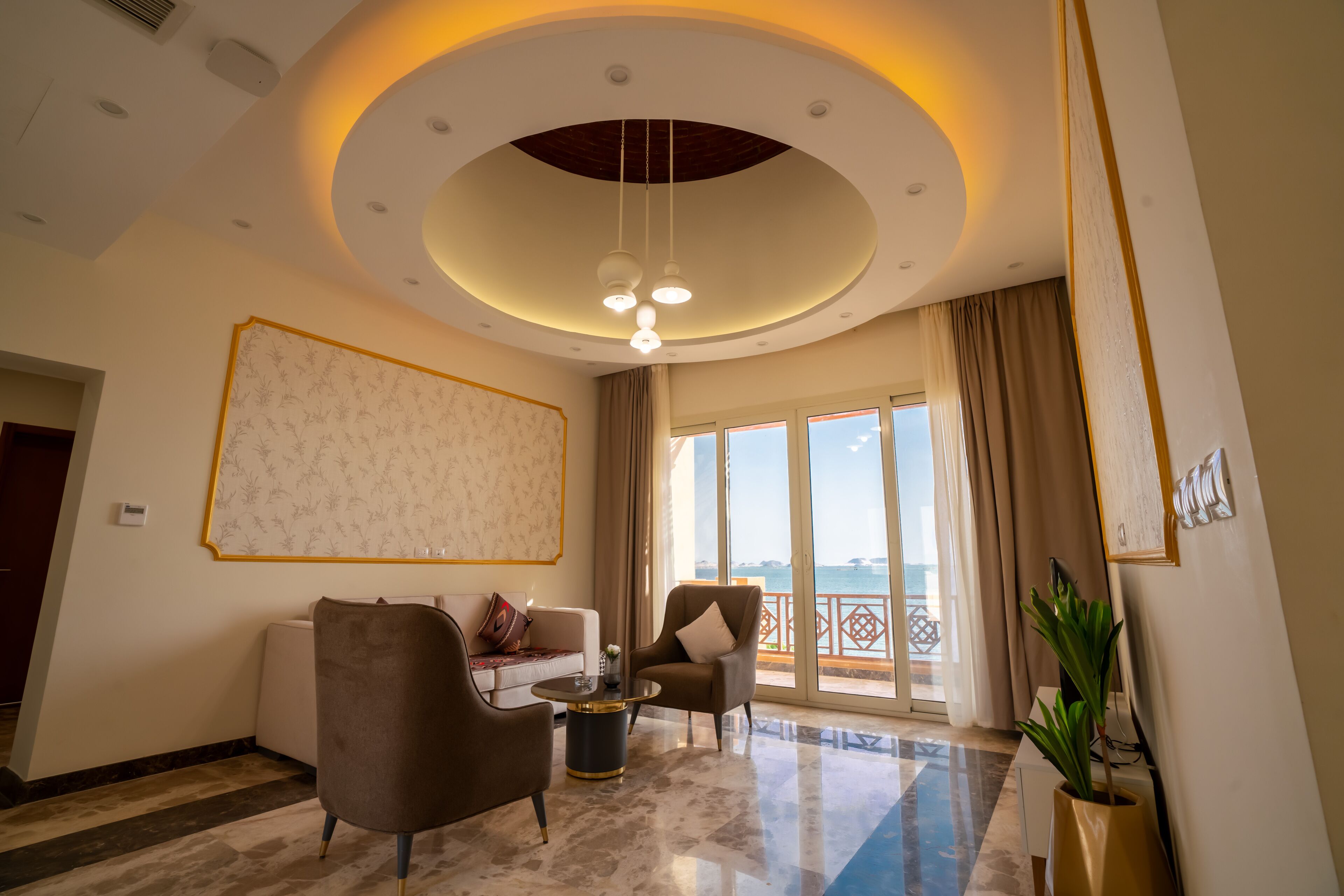 Uma sala de estar espaçosa com uma grande janela, teto com iluminação embutida e design moderno.