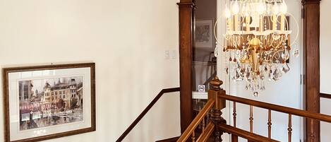 A staircase with wooden balusters and a chandelier.