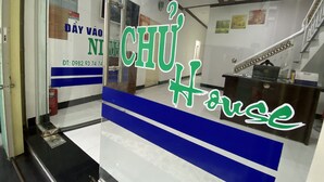 A reception area with a glass door, a staircase, and a desk with a laptop. - Ninh Chu House (Ninh Chu)
