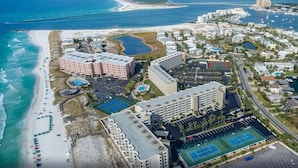 An aerial view of a coastal hotel with multiple buildings, a beach, and a marina. - Dancing Wave, Beachfront, Destin, Holiday Isle (Destin)