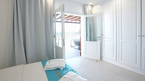 A hotel room with a bed, a bathroom, and a view of the outside.