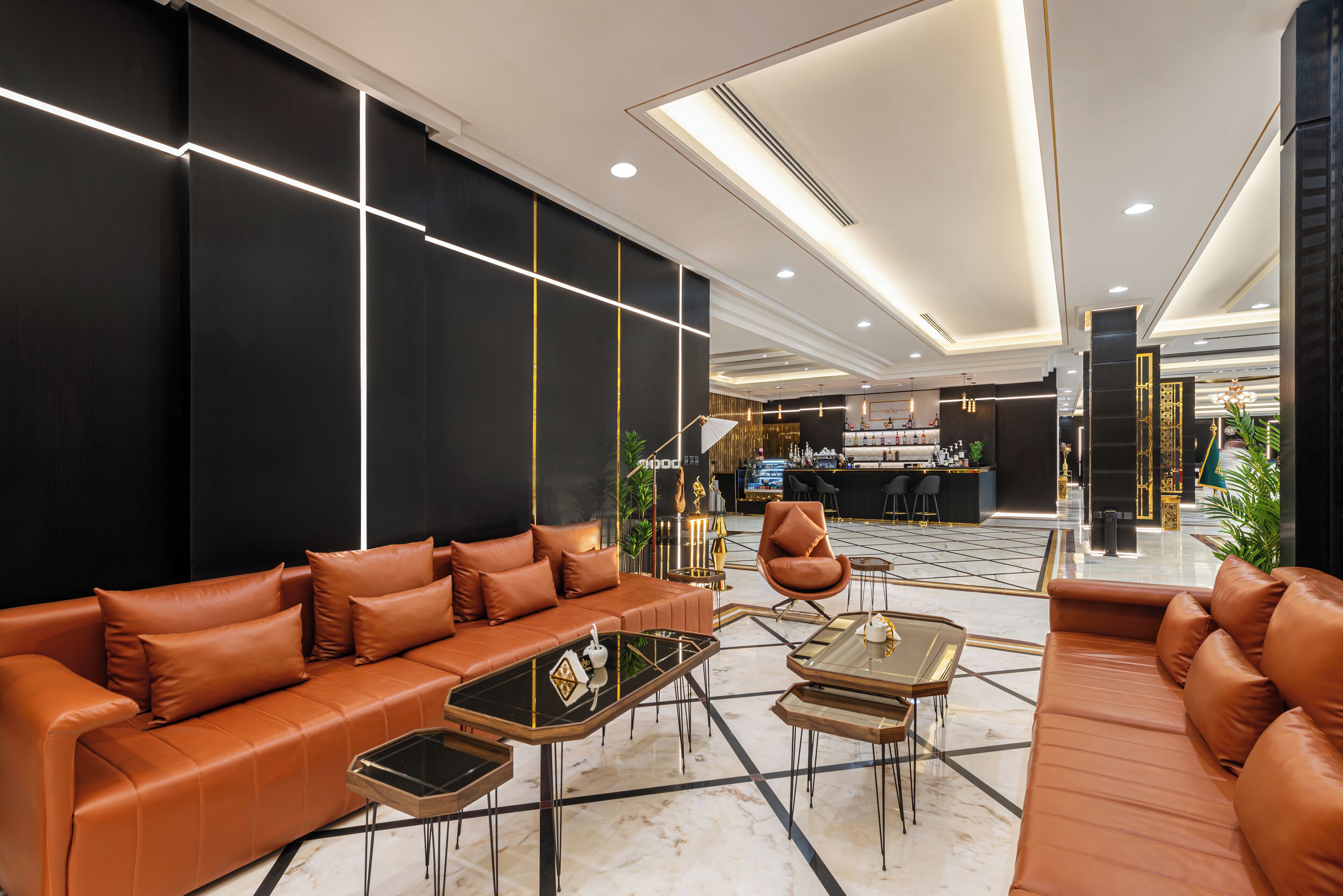 A modern lobby with a leather sofa, a coffee table, and a reception desk.