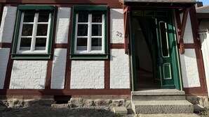 A building with white and brown brick walls, green window frames, and a green door. - Ferienhaus im Altstadtzentrum (Wernigerode)