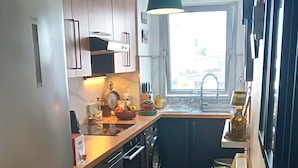 A modern kitchen with a built-in oven, a sink, and a window providing natural light.
