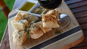 A wooden board with bread and a glass of wine on a table. - Vineyard Suite for a couple in Historical Homestead, relax on family winery.  (Langhorne Creek)