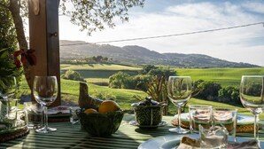 A table set for a meal with a scenic countryside view. - Charming villa in Chianni,Pool,garden, A/C, Pergola for al fresco dining,sleep 9 (Chianni)
