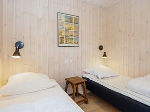 A room with two beds, a small wooden stool, and a framed picture on the wall. - 5 Star Holiday Home in Romo (Rømø)