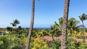 A tropical landscape with tall palm trees and a view of the ocean. - Koana's Ocean Hale Onsite Pool (Kailua-Kona)
