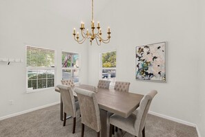 A dining room with a chandelier, a table, chairs, and artwork on the walls. - Peaceful 3bd/2.5ba home w/ yard, garage (Albuquerque)
