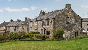 A row of stone houses with a grassy front yard.