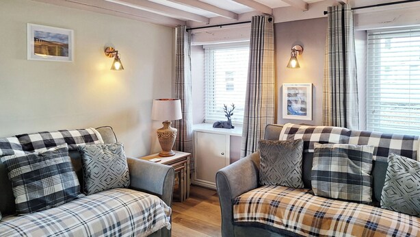 A cozy room with two sofas, a lamp, and a window with curtains.