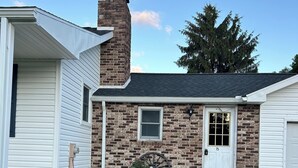 A two-story house with a brick facade, a chimney, and a front door marked with the number 75.