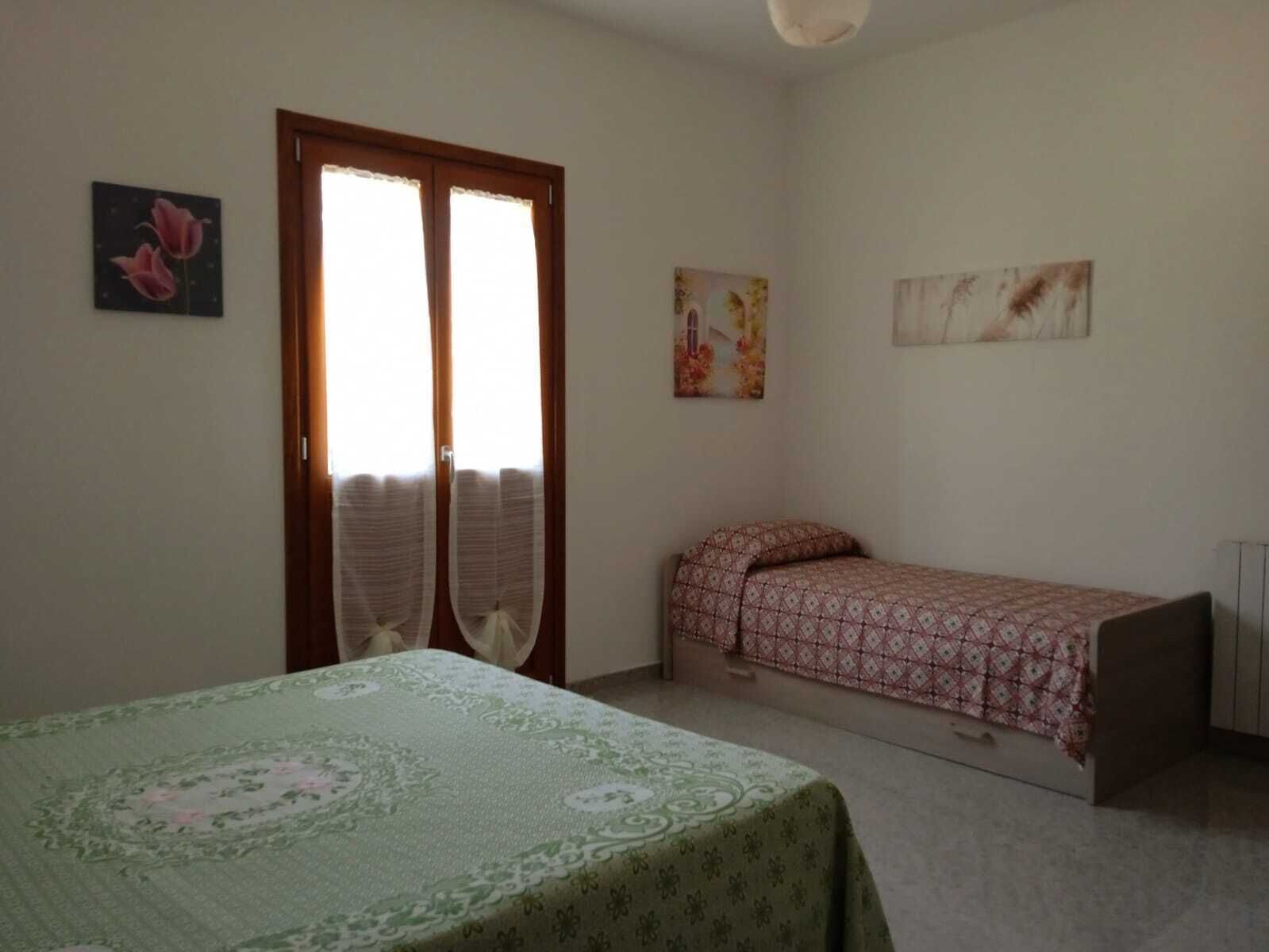 Una camera da letto con un letto, un tavolino e una finestra con tende.