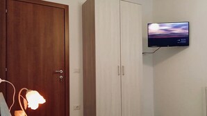 A bedroom with a bed, a nightstand, a lamp, a wardrobe, and a TV mounted on the wall. - I 3 falchi Bed & Breakfast (Pennadomo)