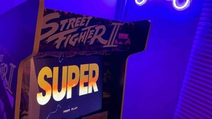 A Street Fighter II arcade machine labeled 'SUPER' with a neon game controller in the background. - Essex 2-bed House nr Stanstead With Arcade Machine (Braintree)