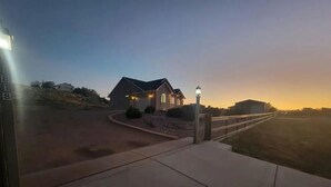 A residential property with a driveway leading to a house, a lamp post, and a clear sky.