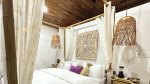 A bedroom with a wooden ceiling, a bed with white bedding, a nightstand, and a decorative wall piece. - BEACHFRONTGEM- owner’s villa-expansive endless beach. Amazing Sept Oct discounts (Savegre)