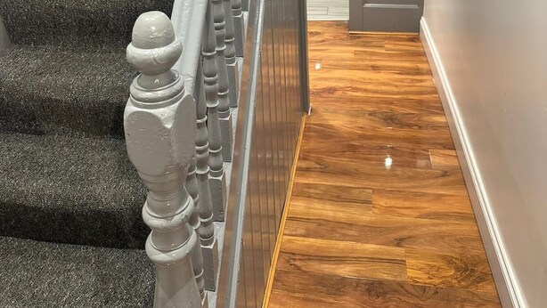 A staircase with carpeted steps and a wooden handrail. - Kuramoh Modern Apartment (London)