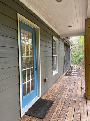 A house with a blue door, a wooden porch, and a welcome mat.