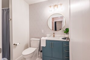 A bathroom with a toilet, a sink with a mirror, and a cabinet.