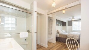 Ein modernes Badezimmer mit einer Glasdusche, einem weißen Waschbecken und einem Handtuch an der Wand.