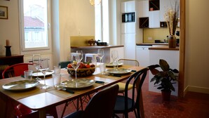 A dining area with a wooden table set for four, equipped with plates, glasses, and cutlery. - Proche DU Vieux Port AU Calme (Marseille)