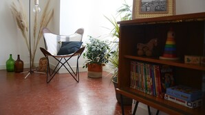 A room with a chair, bookshelf, and potted plants. - Proche DU Vieux Port AU Calme (Marseille)