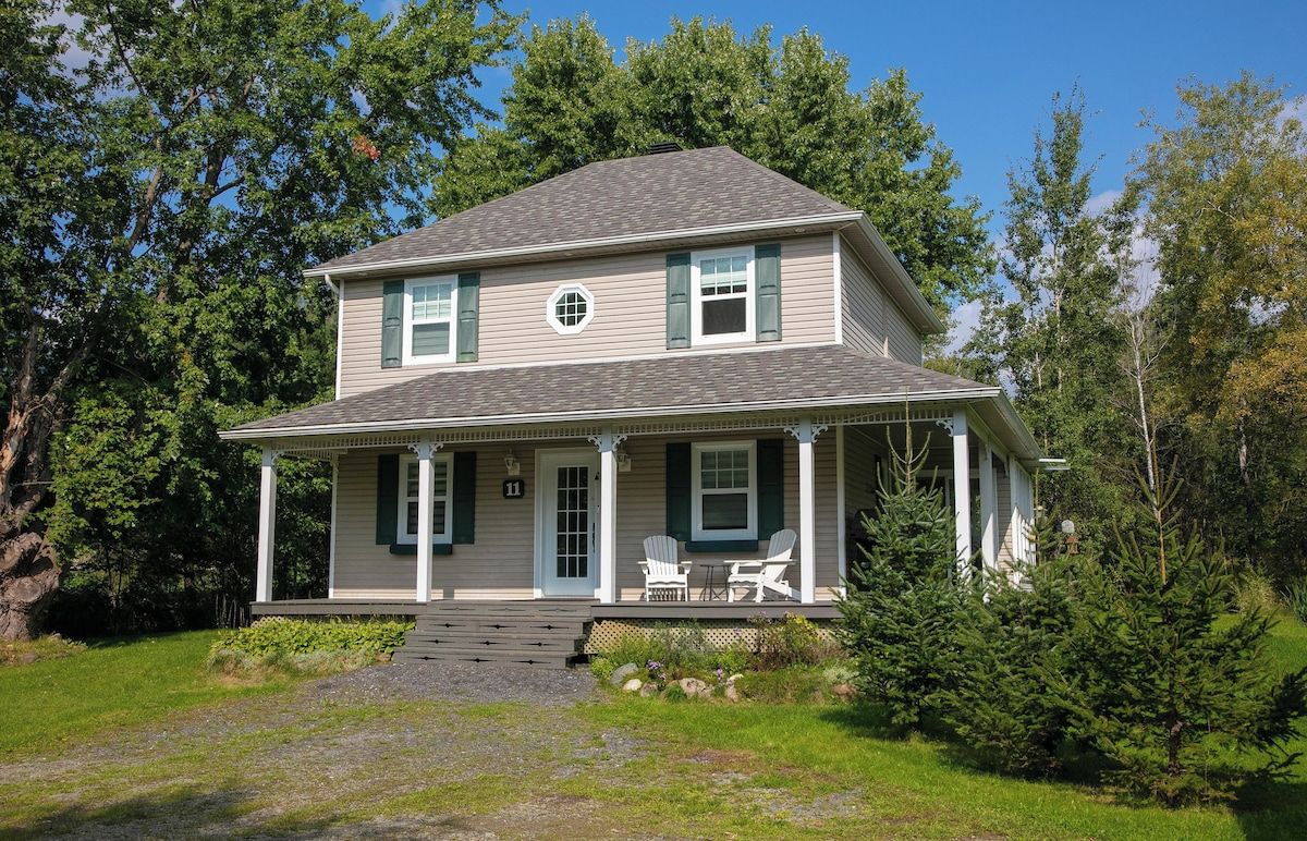 A two-story house with a porch, a chimney, and a number 11 sign.