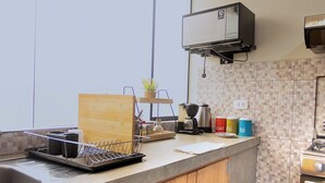 A modern kitchen with a built-in oven, a coffee maker, and a dish rack. - Hermoso y Tranquilo Loft con Netflix Incluido (Lima)