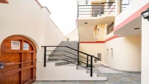A multi-level building with a staircase, a wooden door, and a tiled floor. - Hermoso y Tranquilo Loft con Netflix Incluido (Lima)